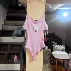 Gold chain detail on side cut-out and for the top straps. Baby pink one piece